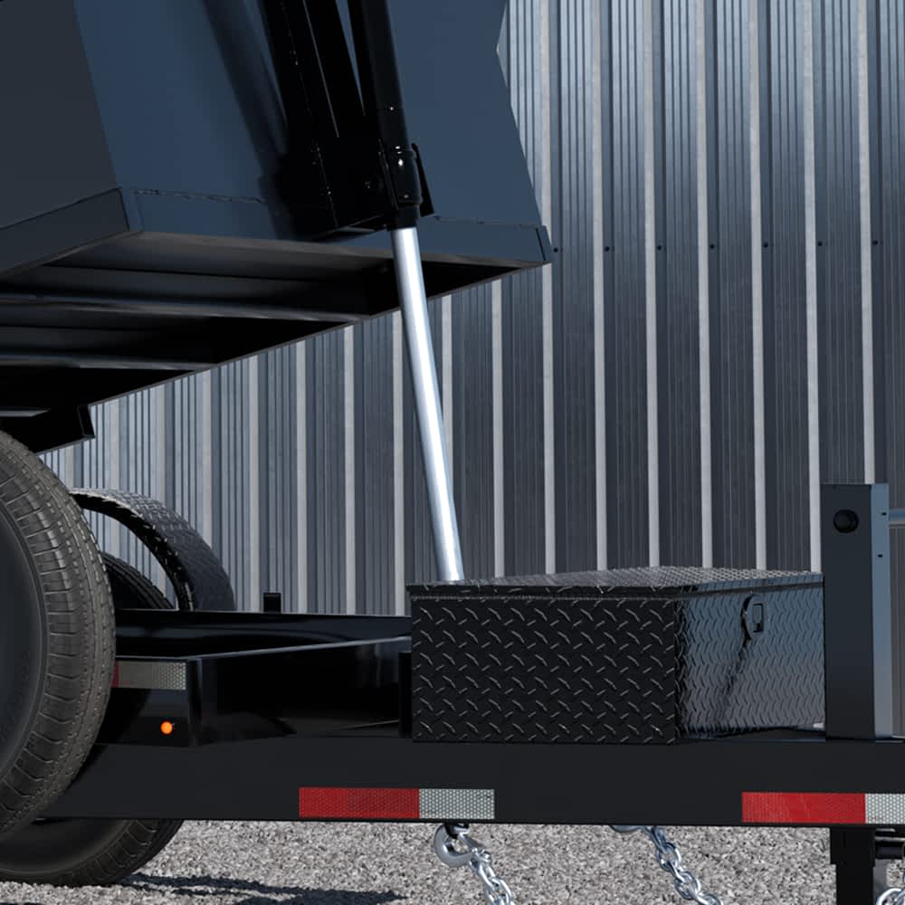 A Texas Pride Trailer dump trailer is shown with its hydraulic lift system engaged, raising the bed for unloading. The sturdy diamond-plate toolbox and heavy-duty construction highlight its durability and functionality.