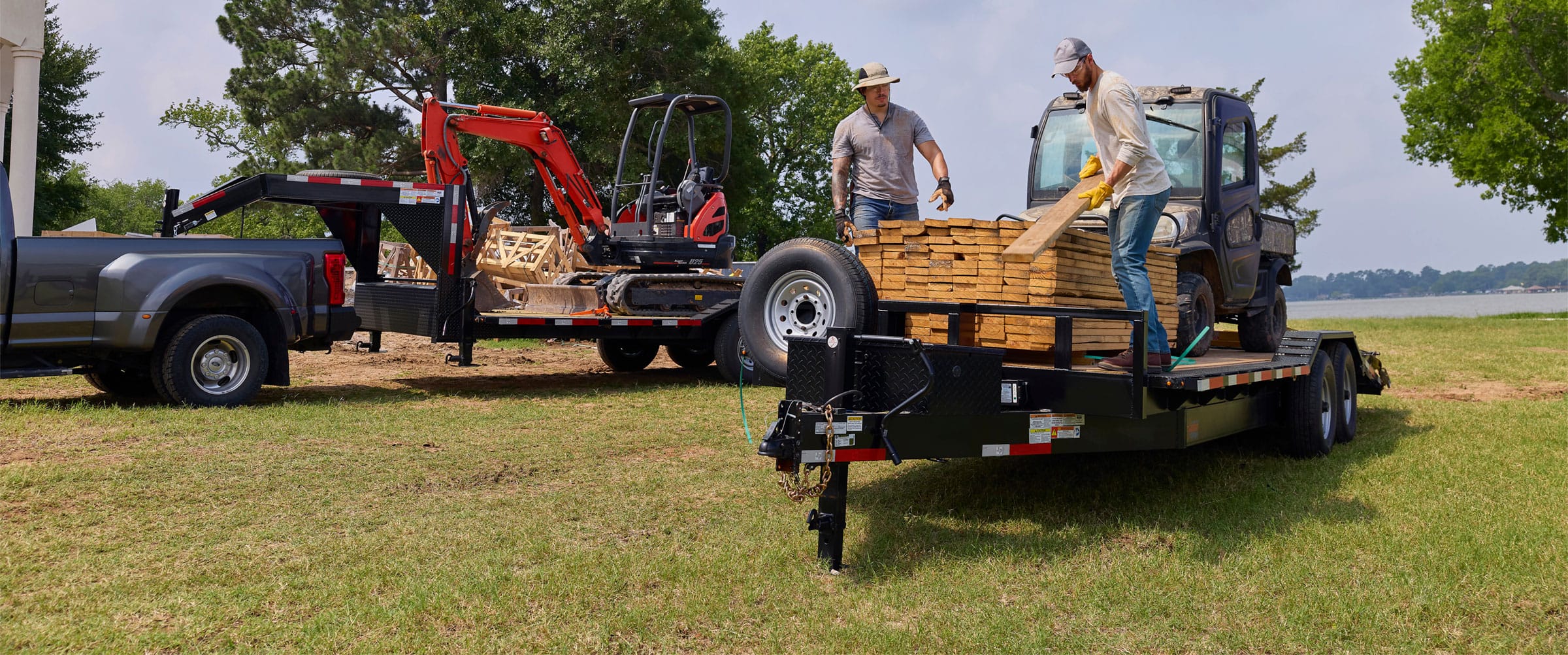 Two men loading lumber on a Texas Pride Trailer.
