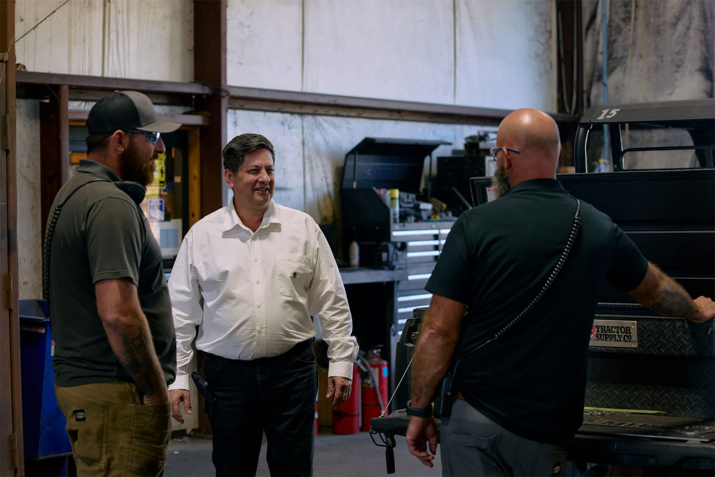 Three men chatting in a workshop