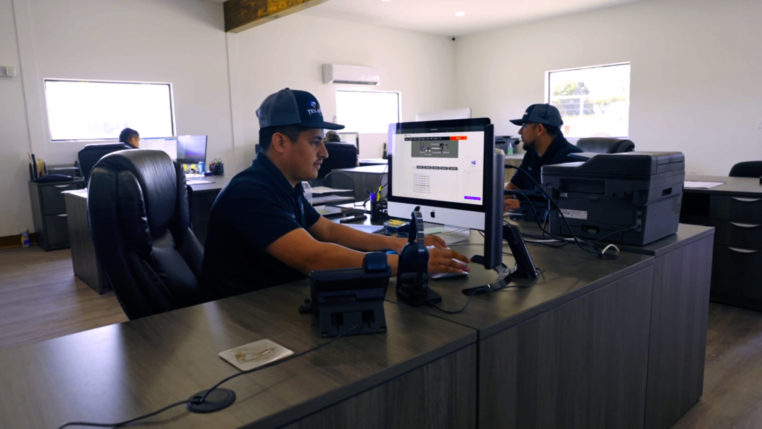 Sales and Support personnel at desks with computers in an office at a Texas Pride Trailers facility.