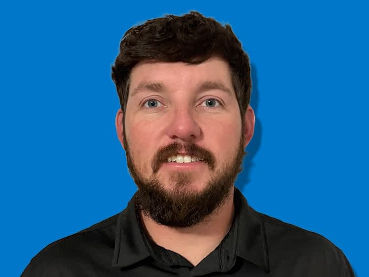 Texas Pride Trailers Location Manager in East Bend, North Carolina wearing a black collared shirt in front of a blue background.
